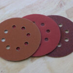 Circular sanding pads on wooden background