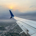 Airplane wing against sunset, while flying over Salt lake city, utah