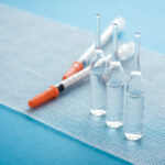 Ampules and syringes on steile bandage surface. Close up image of medical supplies.