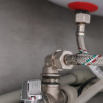 Connection of water supply, hot and cold water to the boiler. Hose for hot and cold water in the bathroom. Plumbing connections for a domestic electric water heater