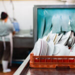 Dishwasher and staff with sink at restaurant