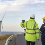 people engineer are wearing a protective helmet on head, using tablet Analytics engineering data.