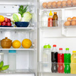 Look into the refrigerator with the lid open a lots of fresh food and drinks inside.
